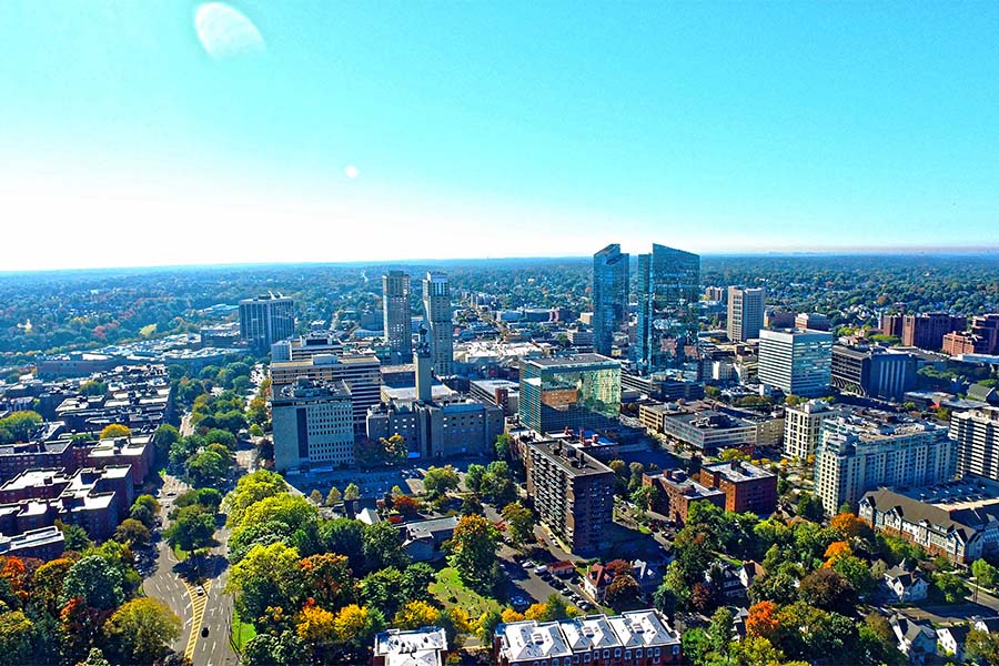 Contact - Aerial View of Downtown White Plains New York Surrounded by Colorful Trees on a Sunny Day